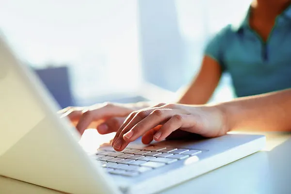 Image of a person typing on a laptop keyboard, suggesting engagement and interaction with the contact form on the Contact Us page